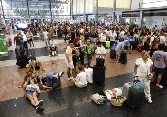 Gente agolpada y tirada en el suelo de la estación de trenes María Zambrano, este lunes.