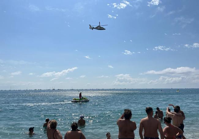 El helicóptero de la Guardia Civil, este domingo sobrevolando la playa torreña.