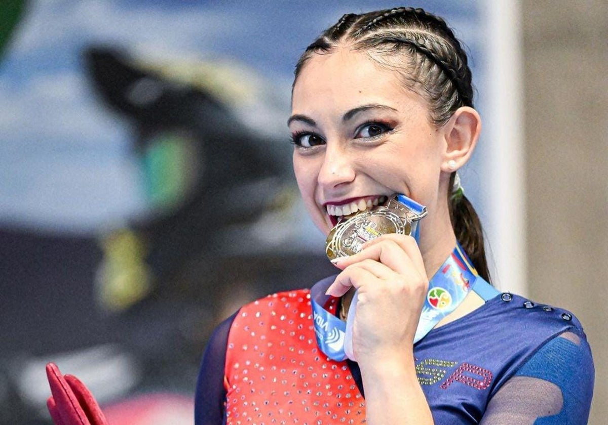 Baldizzone mordiendo la medalla de plata del Mundial de patinaje artístico.