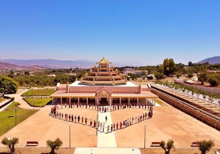 Un grupo de personas forman un corazón en la entrada del Templo Kadampa.