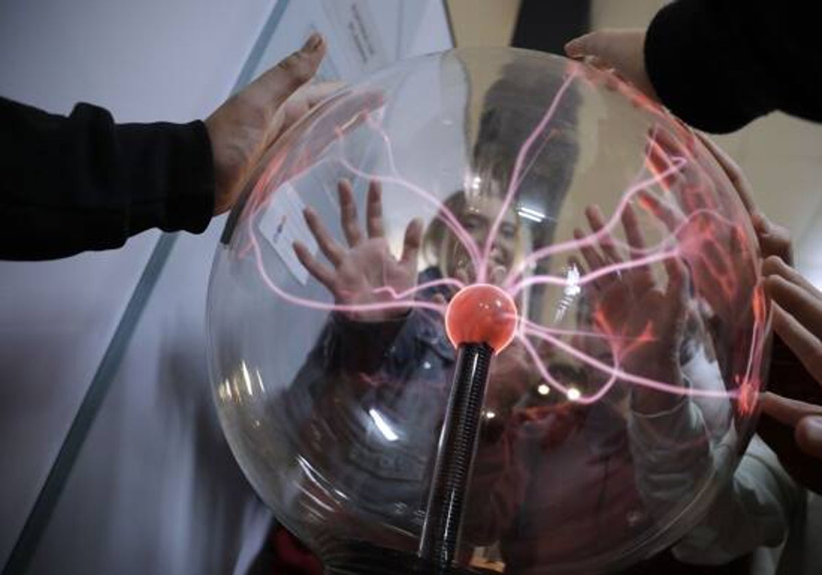 Estudiantes, con la Esfera de Plasma, en la sala de módulos interactivos del Centro Principia.