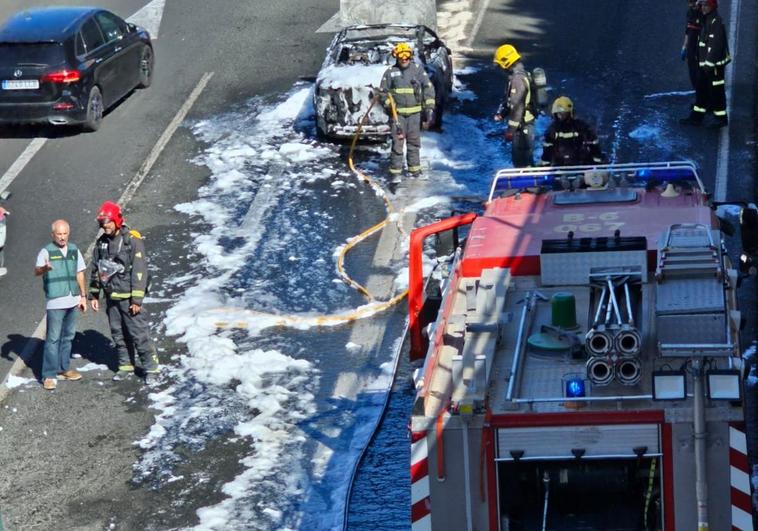 Bomberos y Guardia Civil, junto al coche quemado.