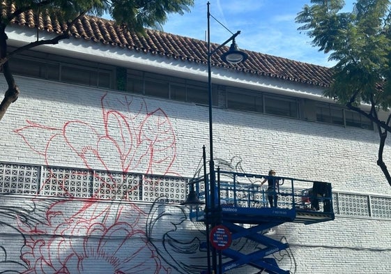 La artista urbana, Lula Goce, trabajando en las paredes del mercado.