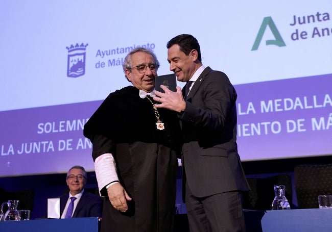 Juanma Moreno recibe la medalla de oro de la UMA de parte de José Ángel Narváez.