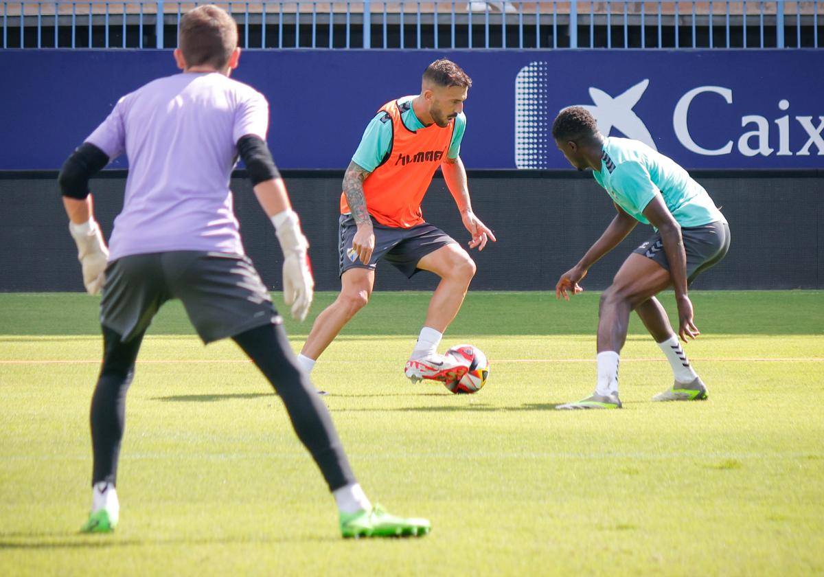 Dioni encara a Moussa ante la mirada del portero Carlos López en un entrenamiento de esta semana del Málaga en La Rosaleda.