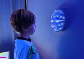 Un alumno de infantil observa el espejo infinito del Aula Nupa.