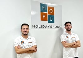 Cuberos y Rubio posan en su oficina junto al cartel de HolidaysForU.