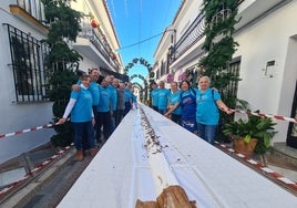 Pasteleros y voluntarios junto al tronco navideño, en la calle Real de Benalmádena.