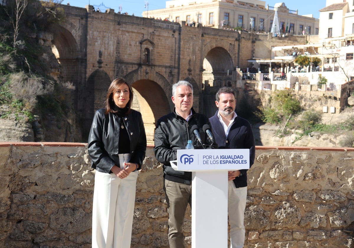 María de la Paz Fernández, Elías Bendodo y José Ramón Carmona y detrás El Tajo.