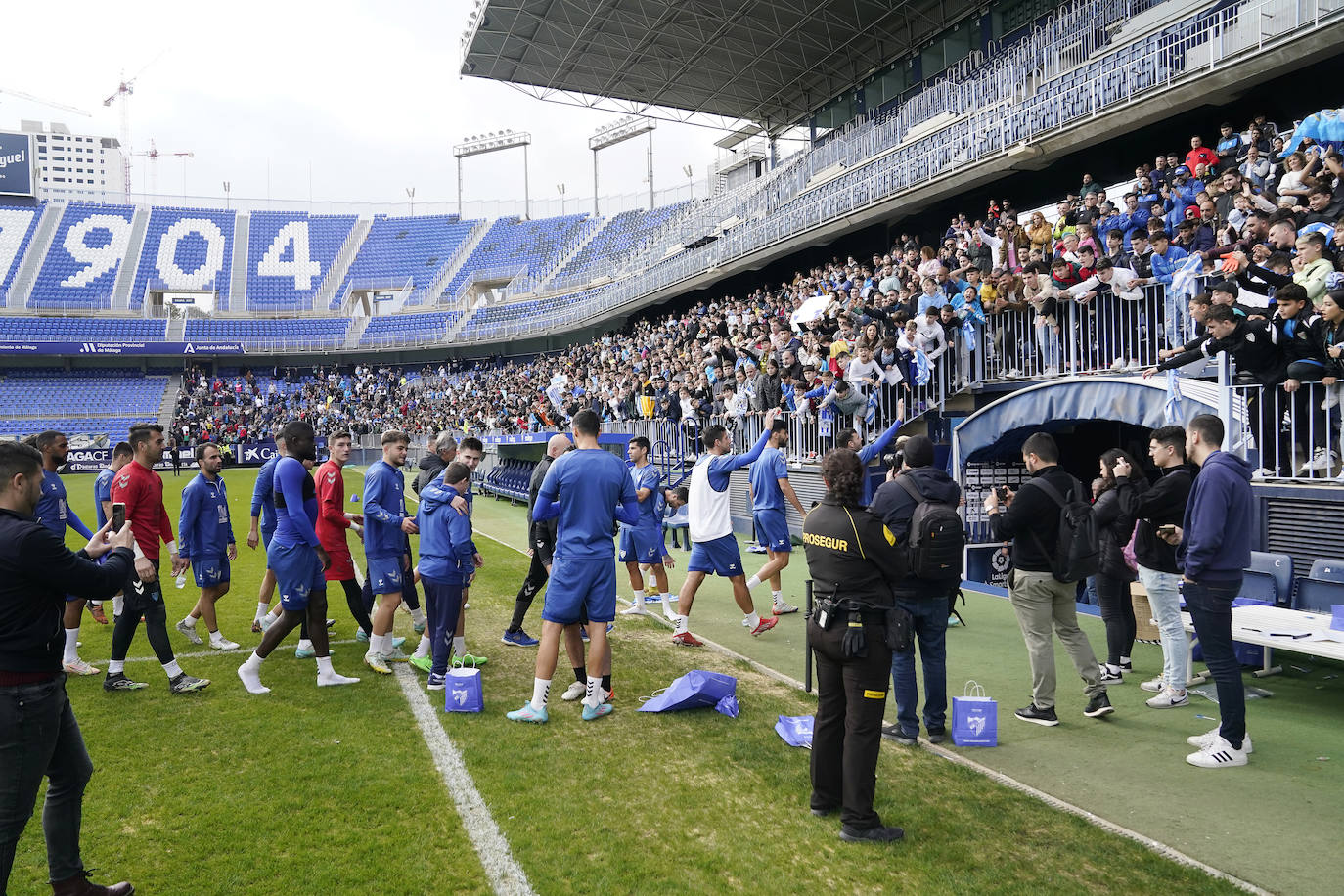 Miles de seguidores, entre ellos muchos niños, acuden en masa a La Rosaleda para ver una sesión de trabajo del equipo blanquiazul en la víspera del Día de Reyes. 