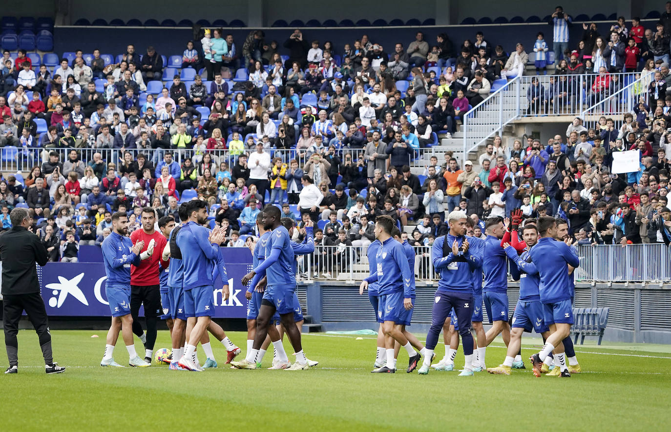 Miles de seguidores, entre ellos muchos niños, acuden en masa a La Rosaleda para ver una sesión de trabajo del equipo blanquiazul en la víspera del Día de Reyes. 