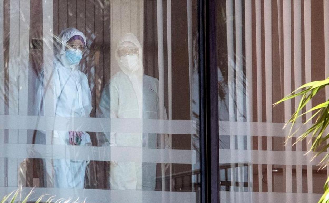 Dos trabajadores con trajes de protección en el interior de la residencia de mayores en Cádiz en plena pandemia. 