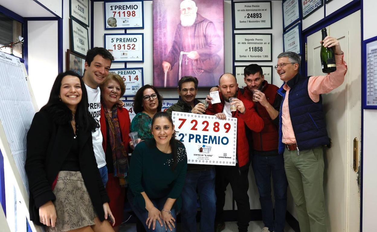 Agraciados con un décimo del segundo premio, junto a propietarios y trabajadores de la administración de loterías Fray Leopoldo. 