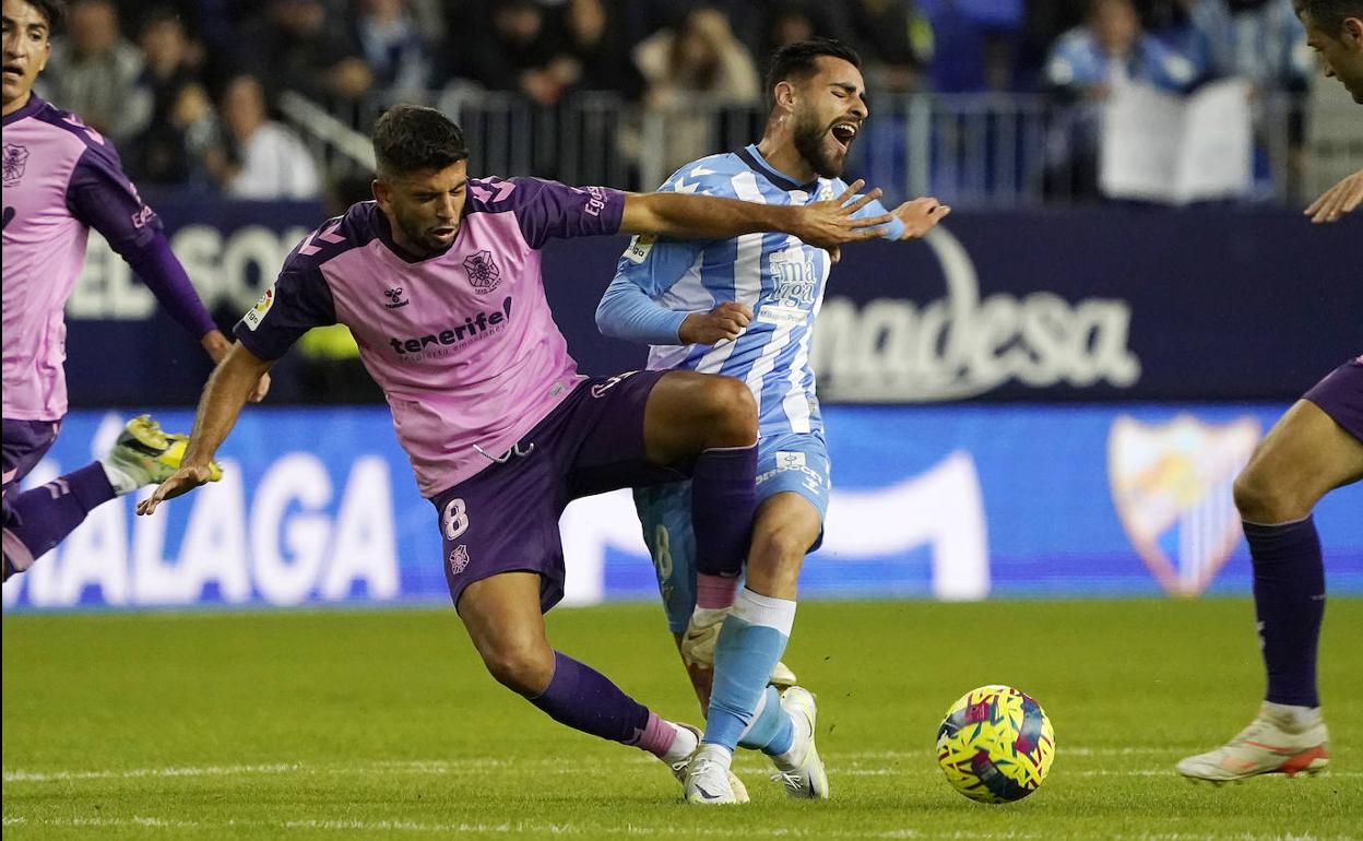 Luis Muñoz recibe una entrada de Javi Alonso en el partido del Málaga contra el Tenerife.