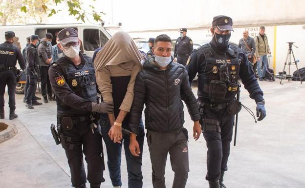 Policías nacionales trasladan a varios de los detenidos por la entrada ilegal a través del aeropuerto de Palma en noviembre de 2021. 