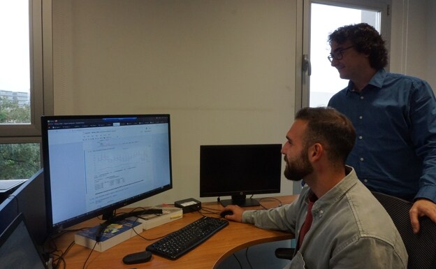 Sandro Hurtado e Ismael Navas observan una tabla de datos en el laboratorio. 