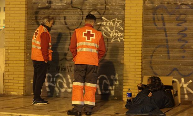 Imagen principal - Distintas escenas de las ayudas de los voluntarios a gente en situación de calle. 