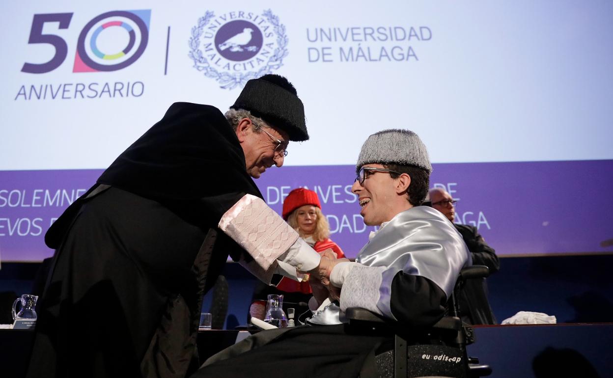 Pablo Guzmán Sancho, graduado en Periodismo y doctor en Ciencias de la Comunicación, recibe el abrazo del rector en la ceremonia de investidura. 