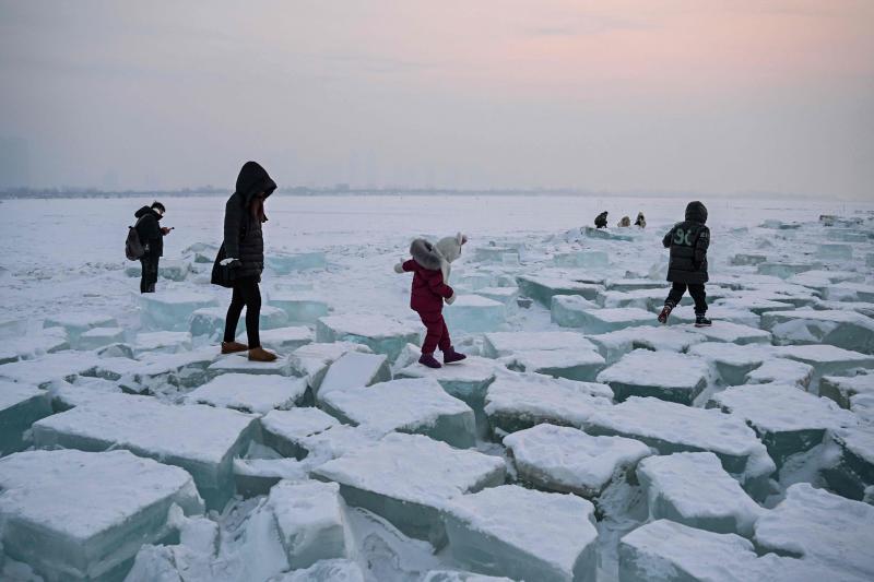 Varias personas caminan sobre el hielo en la provincia china de Heilongjiang. 