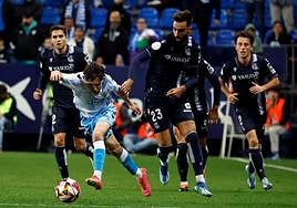El jugador del Málaga Aarón Ochoa intenta zafarse de Brais Méndez, rival de la Real Sociedad, en una acción del partido de Copa del Rey disputado en La Rosaleda.