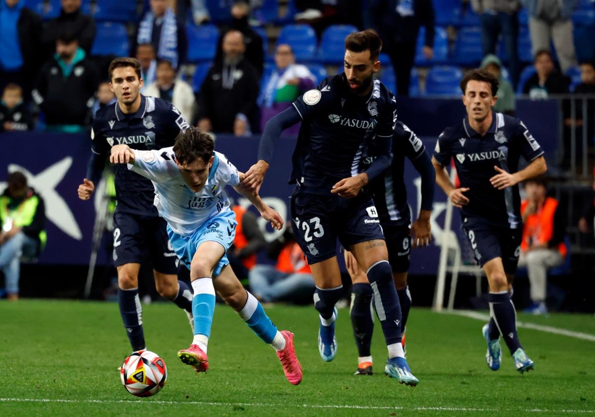 El jugador del Málaga Aarón Ochoa intenta zafarse de Brais Méndez, rival de la Real Sociedad, en una acción del partido de Copa del Rey disputado en La Rosaleda.