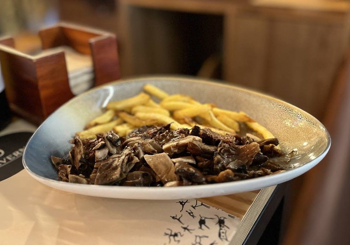 La carrillada de ternera se sirve con patatas fritas y un confitado de setas.