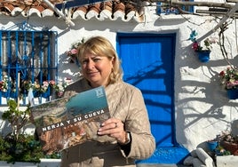 La concejala nerjeña de Turismo, Ana Muñoz, con material promocional en la playa de Calahonda.