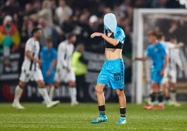 La decepción de un jugador del Antequera mientras el Castellón celebra uno de sus goles.