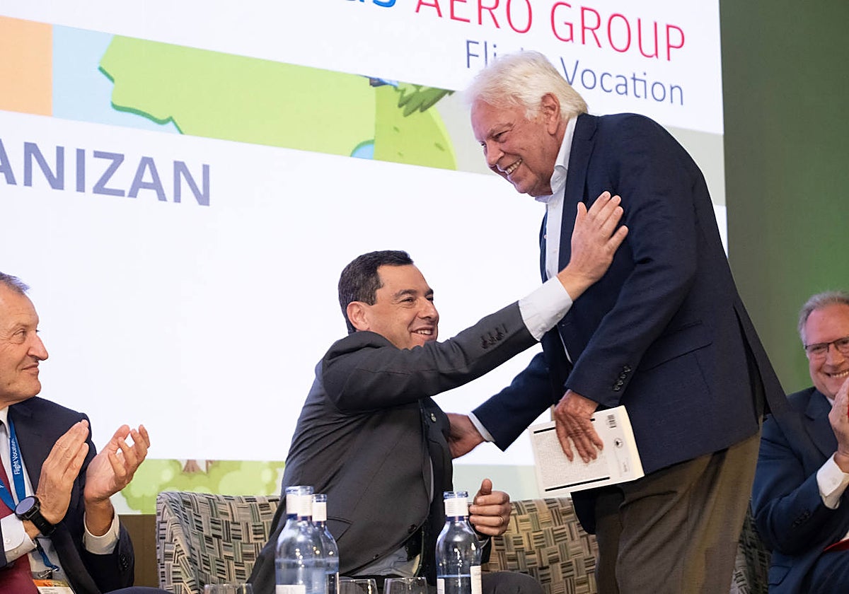 Juanma Moreno saluda a Felipe González en un momento del acto.