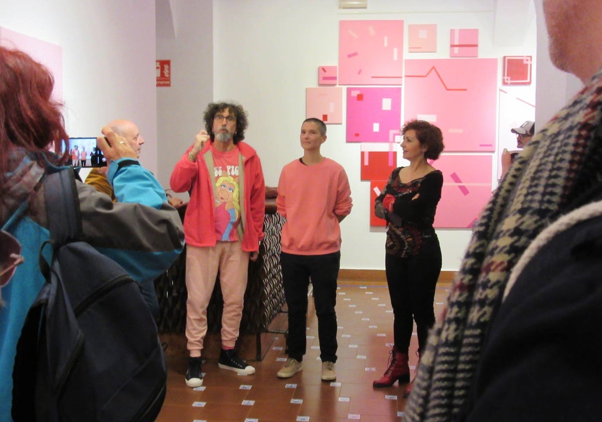 La artista Evelyne Rigaud con su exposición de fondo.