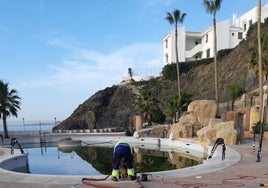 Operarios municipales recogen el agua de una piscina, donada por un hotel de Benalmádena.