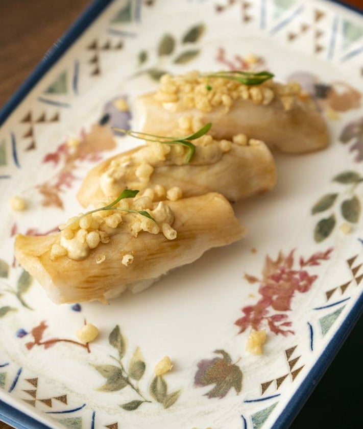 Imagen secundaria 2 - Arriba, tiradito a la crema de ají amarillo. Abajo, gyozas de anticucho y nigiris de pez mantequilla.