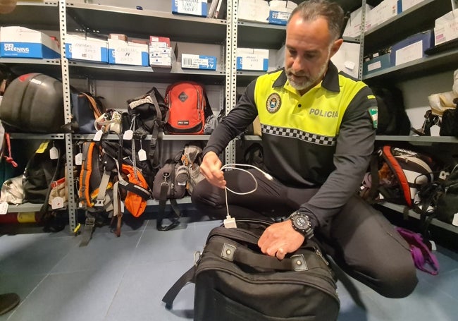 El policía Miguel Puertas muestra el interior de una de las maletas que se encuentran en la oficina.