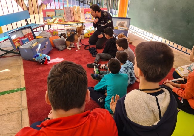 El policía David Gutiérrez presenta a Bobby a los niños del centro El Albero.