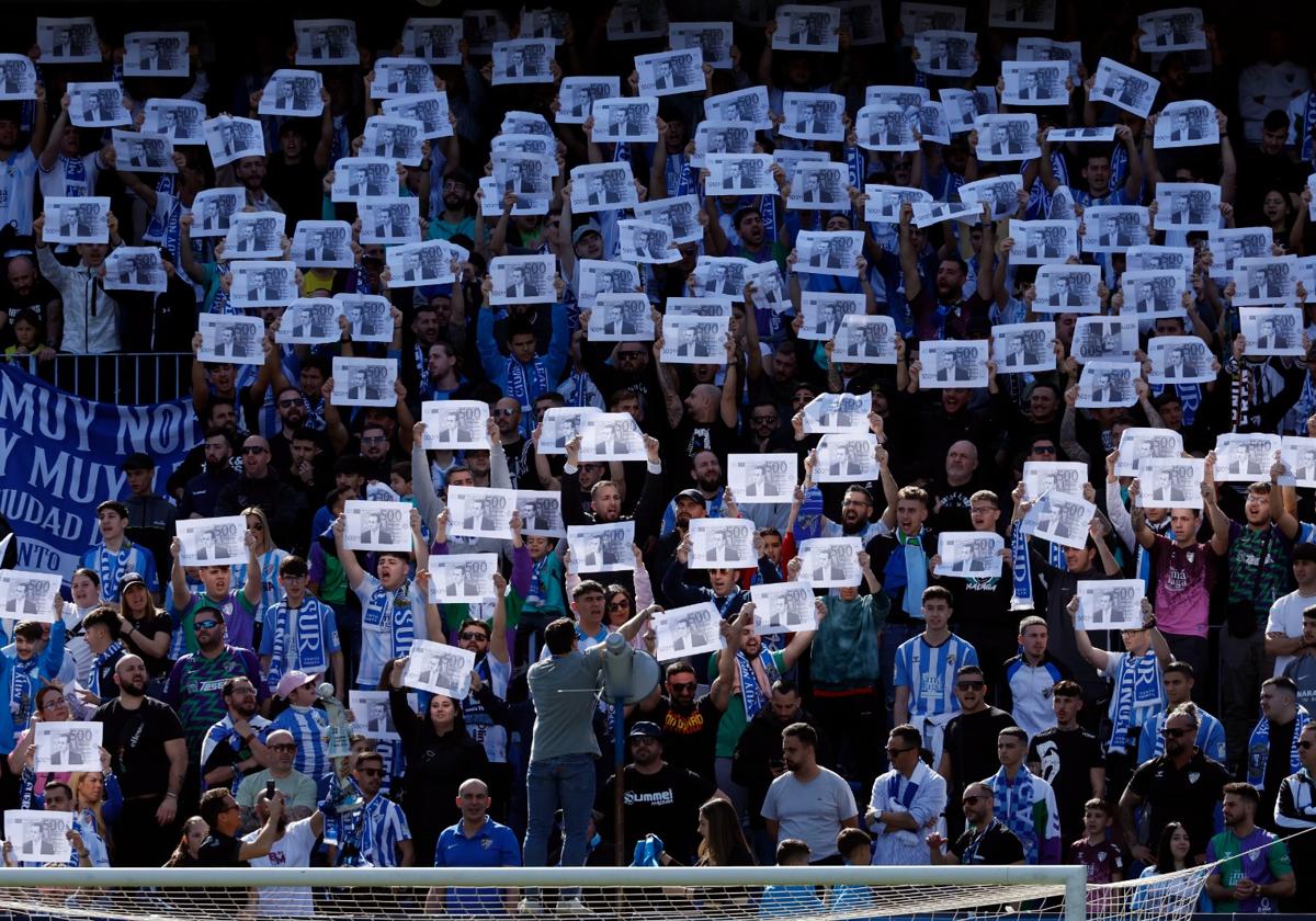 Aficionados de la Grada de Animación del estadio de La Rosaleda protestan contra el administrador judicial, José María Muñoz, mostrando billetes de 500 euros con su cara durante el partido contra el Recreativo de Huelva.