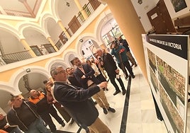 Salado y Rodríguez observan información sobre escenarios de un «tsunami en Rincón», mientras Juan Conesa se dirige a público.