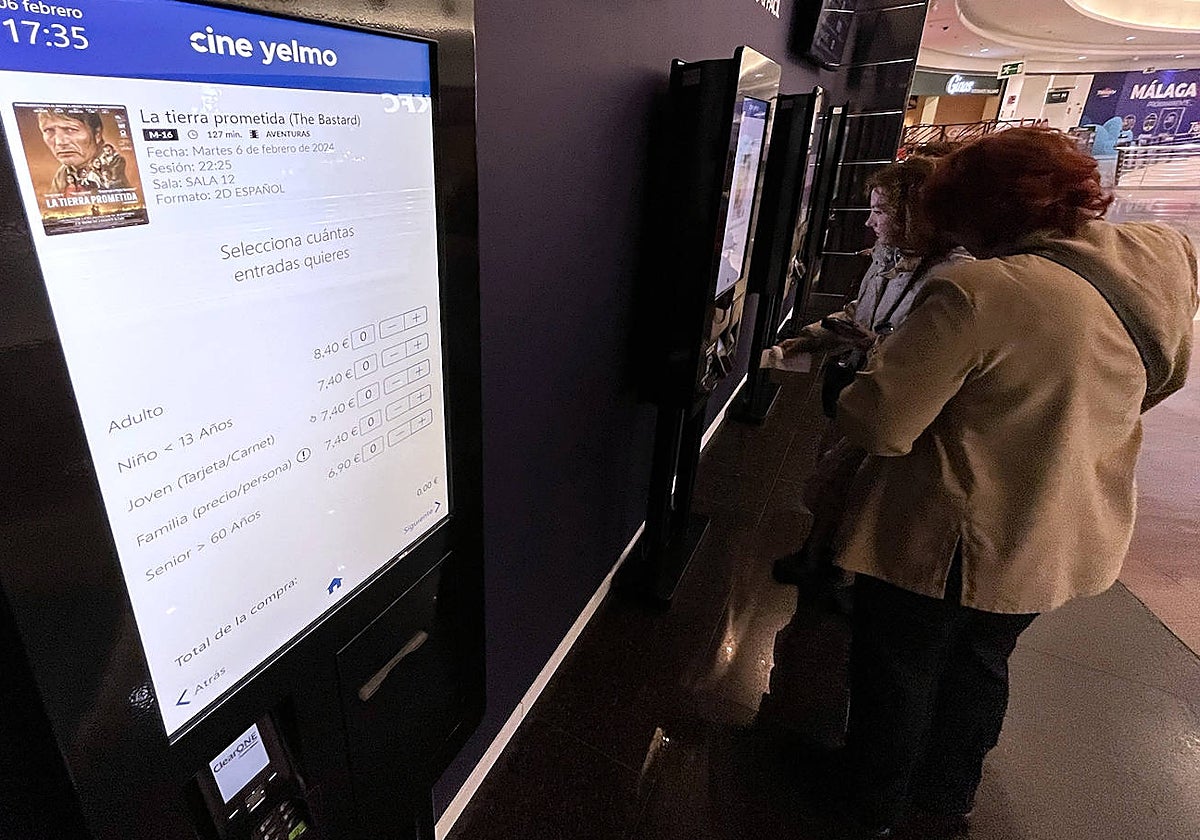 Unos espectadores sacan una entrada en las taquillas digitales de Vialia.