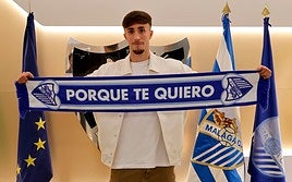 Larrubia posa con una bufanda del Málaga en las oficinas de La Rosaleda después de firmar su renovación con el club este lunes.