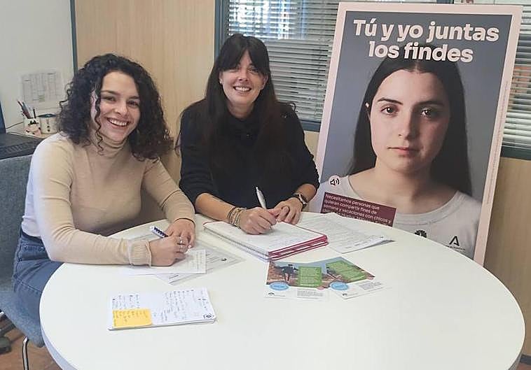 Luisa Bueno (dcha), trabajadora social de la ONG 'Crecer con Futuro', con Sara Gómez y el cartel de la campaña 'Tú y yo juntos los findes'