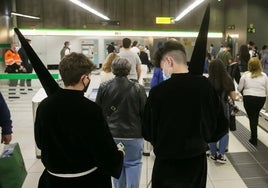 Jóvenes nazarenos, en el interior de una estación del metro.