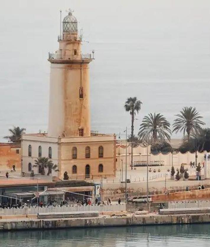 Imagen secundaria 2 - Imagen desde el puerto. El barro, en fachadas, coches y en la propia Farola de Málaga, hace dos años