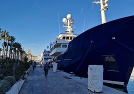 En primer término, una de las torretas de electricidad desplegadas en la marina, junto a un yate amarrado.