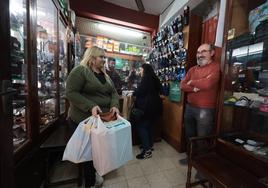 Francisco Herrero y su hijo Carlos atienden a dos clientas que pasan por la tienda.