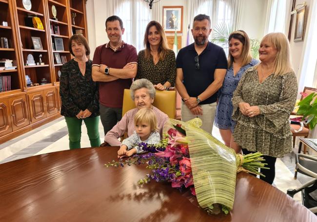 Josefa, sentada con su bisnieto y acompañada de su familia y de la alcaldesa de Mijas.