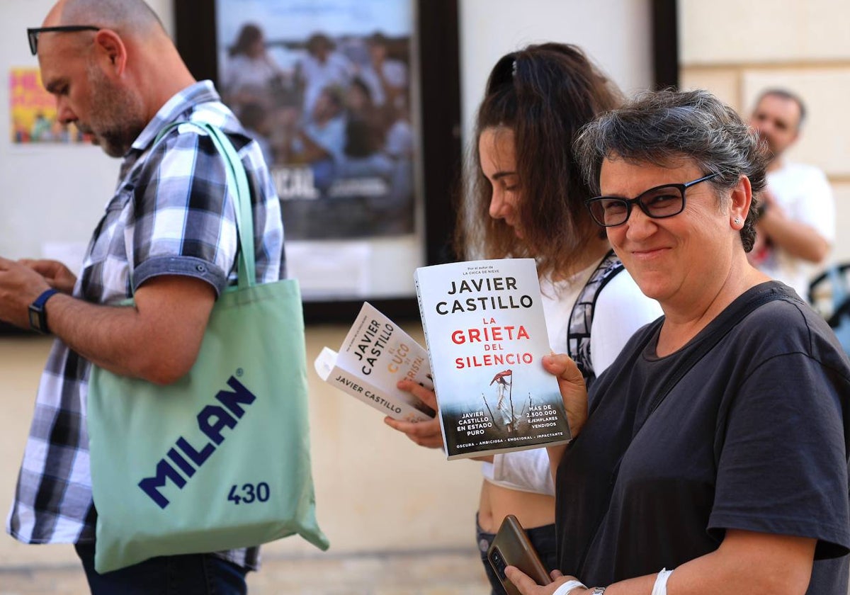 Lectores leyendo el nuevo libro de Castillo mientras hacían cola antes de la presentación en el Aula SUR.