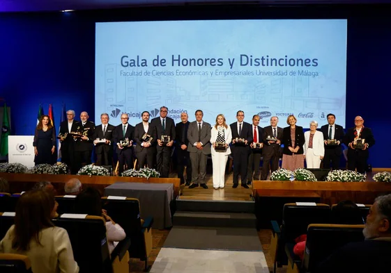 El rector, Teo López, y el decano, Eugenio Luque, con los antiguos estudiantes reconocidos con las insignias y nombrados alumnos de honor.