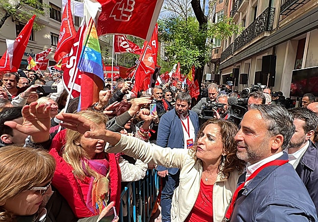 Dani Pérez y la vicepresidenta primera y vicesecretaria general del PSOE, María Jesús Montero, saludan a los congregados ante la sede socialista en Ferraz.
