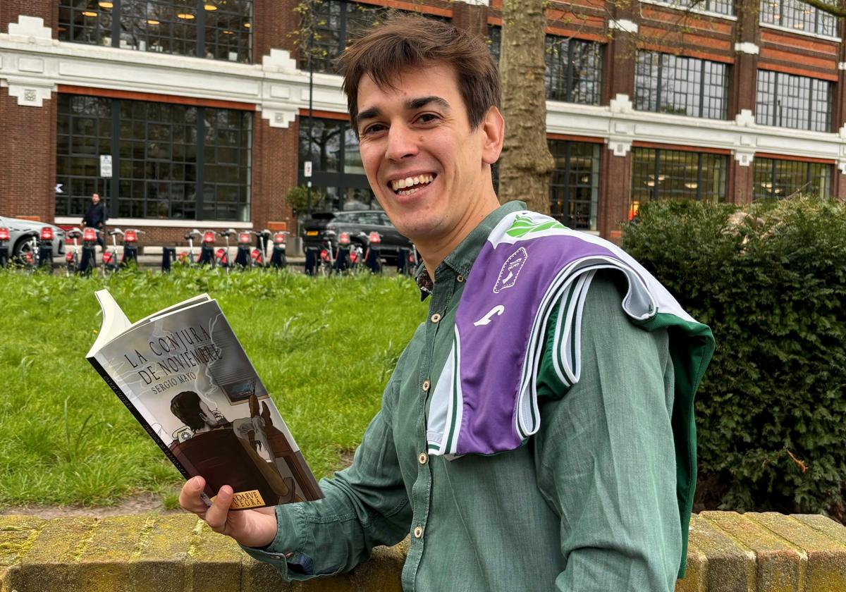 Sergio Mayo posa en Londres, donde reside, con un ejemplar de su libro y una camiseta del Unicaja