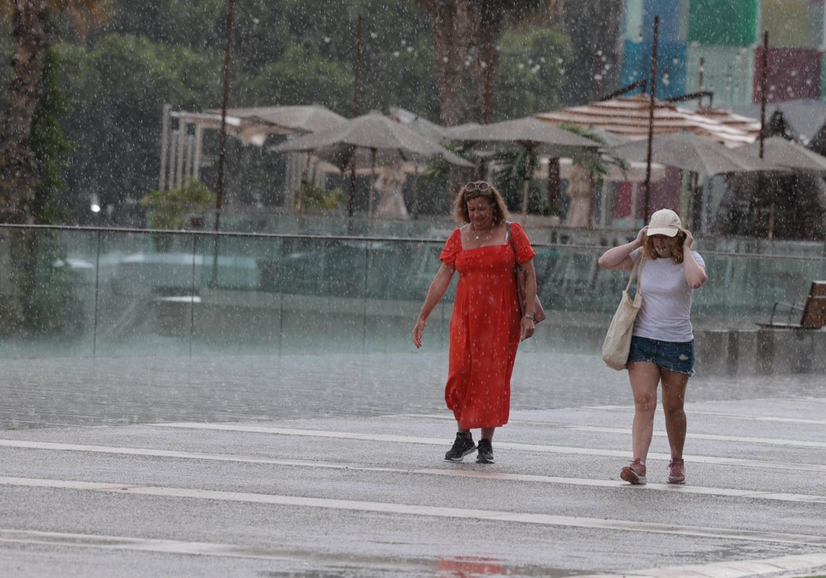 La tormenta sorprende a unas turistas en el Muelle Uno de la capital.