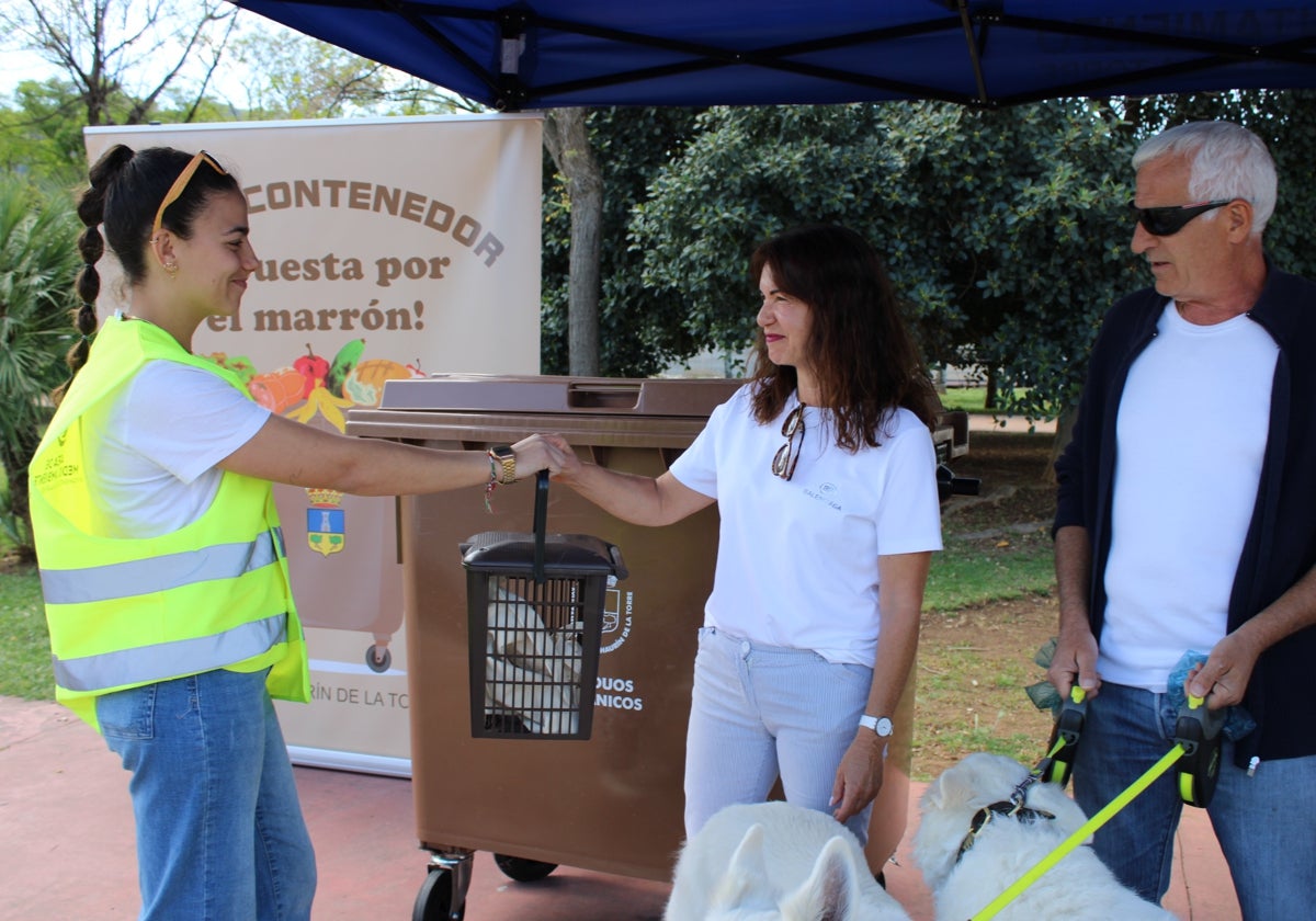 Vecinos reciben información sobre el contenedor marrón en la carpa instalada por el Ayuntamiento para fomentar su utilización.